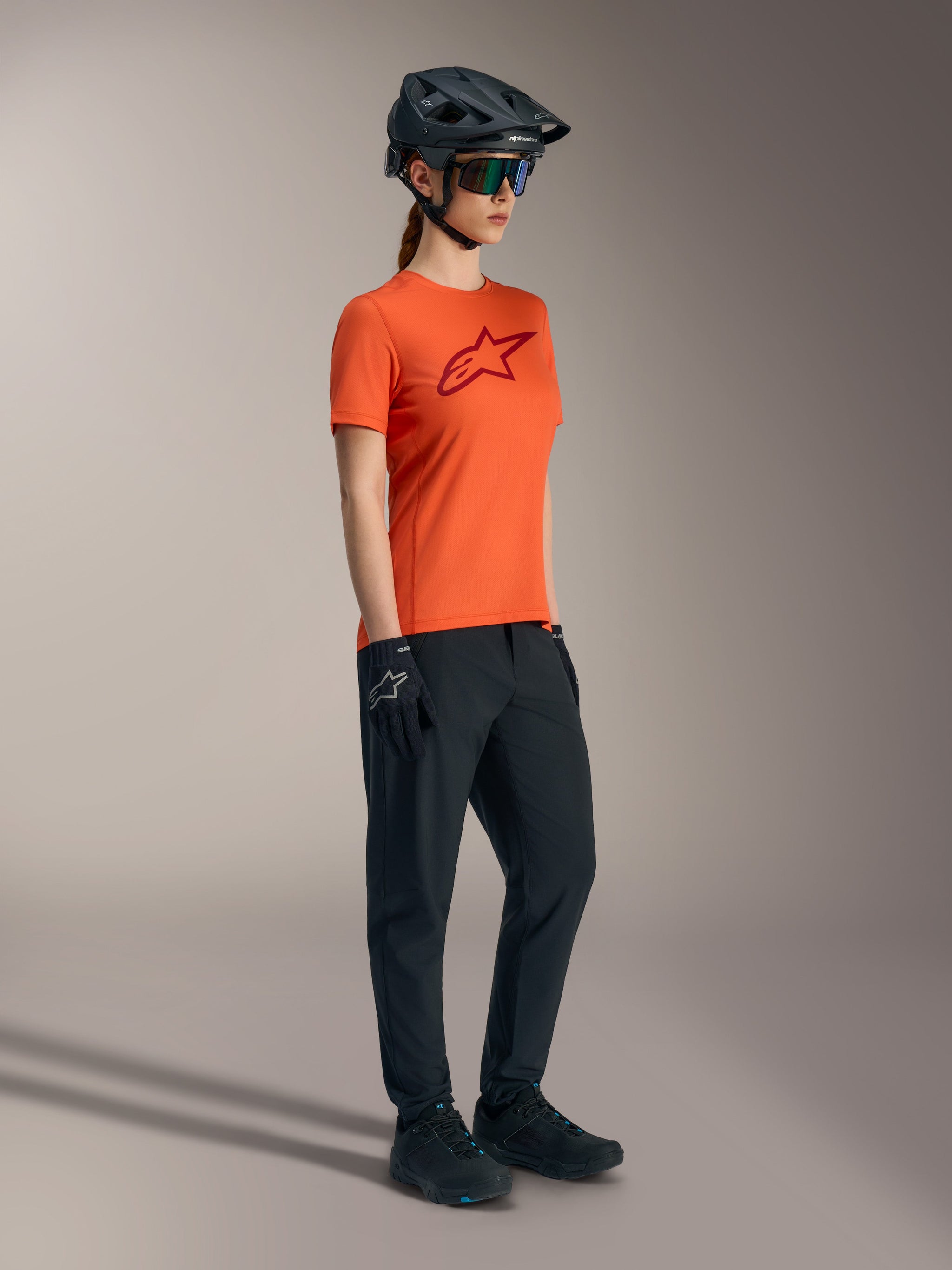 Jersey Stella A-Dura Ride naranja con logo rojo, manga corta, ropa técnica de MTB para mujer.