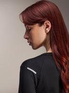 Alpinestars Stella A-Dura Thermal Jersey, jersey de MTB de manga larga para mujer, negro, vista lateral de cerca que resalta la tira plateada reflectante en el hombro, tejido técnico aislante para ciclismo de montaña