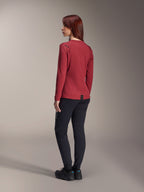 Mujer con pantalones térmicos Alpinestars Stella A-Dura en negro, combinados con un jersey térmico rojo de manga larga y calzado negro, vista trasera, ropa de ciclismo de montaña para montar en climas fríos.