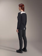 Female rider wearing Alpinestars Women Stella A-Dura Pants and Stella A-Dura Elite Jersey, Black, back view showing white mesh shoulder panels on long-sleeve jersey, slim-fit technical pants, coordinated performance mountain bike gear.