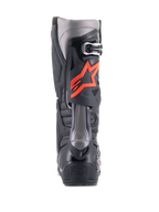 Botas Alpinestars Tech 10, botas de motocross, negro y rojo flúor, vista trasera con carcasa técnica de TPU, paneles gris oscuro y un prominente logotipo de estrella en rojo flúor en la pantorrilla.