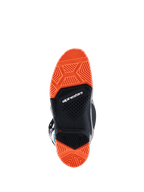Botas Alpinestars 2026 Tech 7 Enduro, vista inferior de la suela especializada de doble compuesto, negro y naranja flúor, patrones de tracción detallados para un agarre superior en off-road, con el logotipo de Alpinestars e indicador de límite de desgaste.