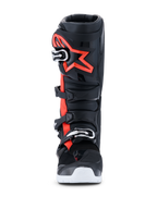 Botas Alpinestars 2026 Tech 7 Enduro Drystar®, botas de motocross y enduro, negro, rojo flúor y blanco, vista frontal, con un sistema de cierre de cuatro hebillas, espinillera de TPU reforzada con un gran logotipo rojo de Alpinestars y suela blanca, diseñadas para un rendimiento impermeable off-road.