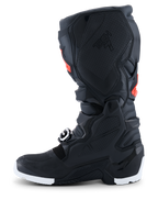 Botas Alpinestars 2026 Tech 7 Enduro Drystar®, botas de motocross y enduro, negras con detalles en rojo flúor y blanco, vista de perfil lateral que destaca el panel de agarre medial de TPU con diseño de panal y la suela blanca, construcción impermeable y duradera para rendimiento off-road