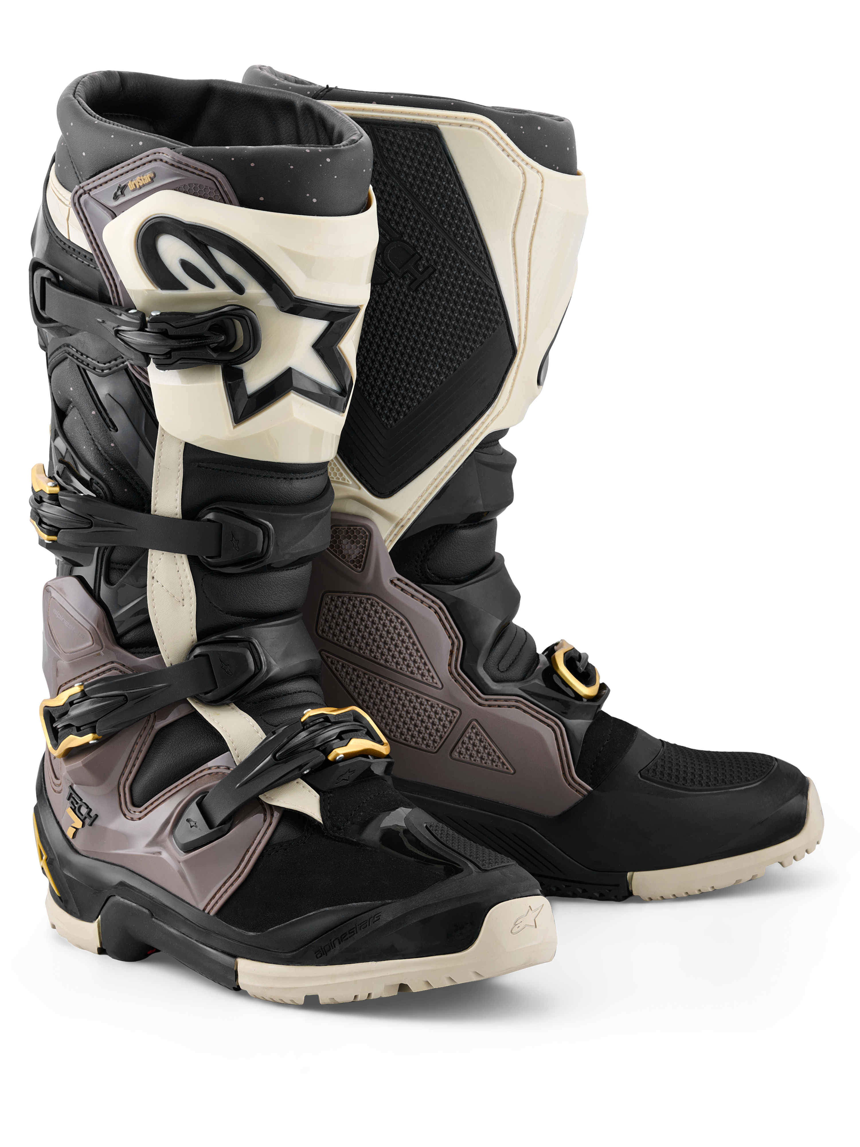 Botas Alpinestars 2026 Tech 7 Enduro Drystar®, botas de motocross y enduro, negro, gris oscuro y dorado, con una resistente carcasa de TPU, hebillas de aluminio de liberación rápida con detalles dorados y una placa de espinilla blanca grande con logotipo negro, diseñadas para durabilidad en terrenos todoterreno.