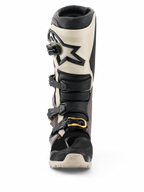 Botas Alpinestars Tech 7 Enduro Drystar® 2026, negro, gris oscuro y dorado, botas de motociclismo off-road impermeables, vista frontal con sistema de cierre de múltiples hebillas con acentos dorados, protección de espinilla en TPU y diseño con el logo de la estrella.