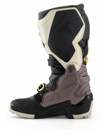Botas Alpinestars Tech 7 Enduro Drystar® 2026, botas de motocross, negro, gris oscuro y dorado, vista de perfil lateral que destaca los paneles de TPU duraderos, la hebilla con detalles dorados y la suela de enduro robusta para conducción off-road