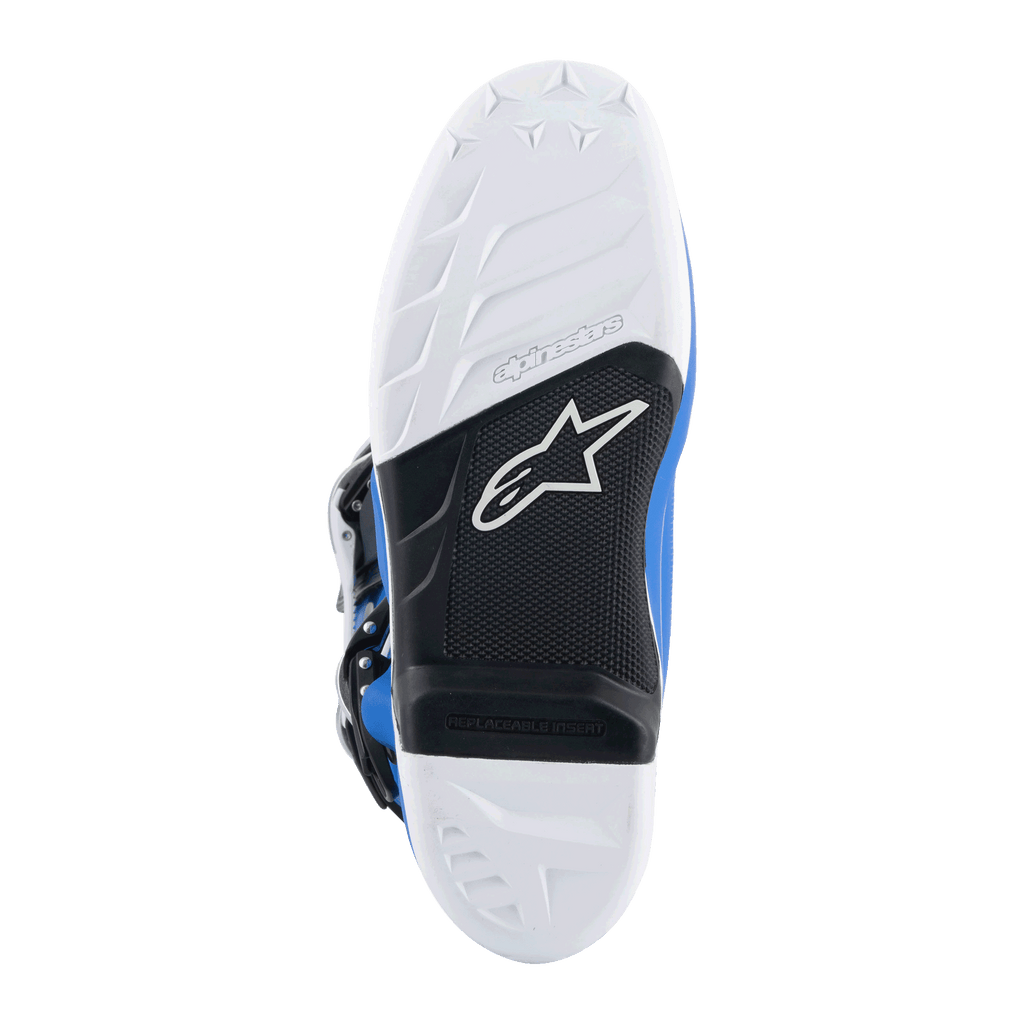 Botas Alpinestars Tech 7, botas de motocross, azul alpino y blanco, vista inferior de la suela con patrón de agarre blanco, arco negro con inserción para estribera reemplazable y logo de Alpinestars, compuesto duradero para carreras todoterreno