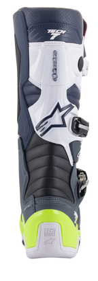 Botas Alpinestars Tech 7, botas de motocross, vista trasera en colores azul oscuro, blanco y gris oscuro con protector de talón amarillo flúor brillante, zonas de flexión en acordeón y marca Tech Series