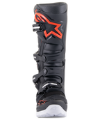 Botas Alpinestars Tech 7 Enduro, negro y rojo flúor, vista frontal, con un gran logotipo rojo en la espinillera, sistema de cierre de cuatro hebillas y detalles blancos en la suela, calzado profesional de motocross y todoterreno.