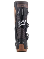 Botas Alpinestars Tech 7 Enduro, color negro y marrón oscuro, vista trasera mostrando las zonas de flexión de acordeón en el tendón de Aquiles y protección de TPU, con el logotipo de la estrella de Alpinestars en blanco y detalles en el talón color canela, diseño robusto para enduro y conducción off-road.