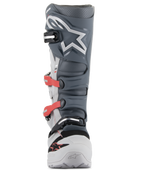 Botas Alpinestars Tech 7 Enduro, botas de motocross y enduro, gris claro, gris oscuro y rojo brillante; vista frontal que presenta un avanzado sistema de hebillas con correas rojas, espinillera de TPU gris oscuro con el logo de la estrella en blanco y un chasis duradero en gris claro.