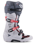 Botas Alpinestars Tech 7 Enduro, botas de moto todoterreno, gris claro y gris oscuro con acentos en rojo brillante, vista lateral con sistema de cierre de múltiples hebillas, pivote biomecánico para mayor estabilidad y paneles de protección de TPU reforzados, suela robusta específica para enduro, equipamiento de alto rendimiento para motocross y conducción por senderos.