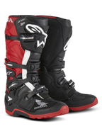 Botas Alpinestars Honda Tech 7 Enduro Drystar®, botas de moto para enduro, negro y rojo brillante, vista frontal en tres cuartos con sistema de cierre de cuatro hebillas, placas protectoras en la espinilla y suelas rojas de gran agarre con logotipos destacados de Honda y Alpinestars.