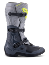 Botas Alpinestars Tech 3, botas de motocross, gris oscuro, gris claro y negro, vista lateral con tres hebillas de polímero negras, paneles de protección de TPU y un logotipo de Alpinestars amarillo vibrante en la zona superior de la espinilla