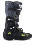Alpinestars Tech 5 Boots, botas de motocross todoterreno, vista de perfil lateral, negro y gris frío con detalles en amarillo flúor, patrón de camuflaje, hebillas ajustables y suela protectora robusta.