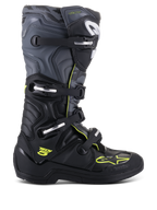 Alpinestars Tech 5 Boots, botas de motocross todoterreno, vista de perfil lateral, negro y gris frío con detalles en amarillo flúor, patrón de camuflaje, hebillas ajustables y suela protectora robusta.