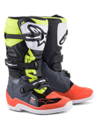 Botas Alpinestars Youth Tech 7S, botas de motocross, gris oscuro con detalles en rojo y amarillo fluorescente, con placa de espinilla de TPU blanca con logo negro, sistema de cierre de triple hebilla y suela blanca duradera, diseñadas para jóvenes pilotos de off-road.