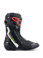 Botas Alpinestars Supertech R, botas de motociclismo de alto rendimiento en color negro con detalles en blanco, rojo flúor y amarillo flúor, con espinillera protectora de TPU con logo rojo, deslizador de punta reemplazable y perfil aerodinámico estilizado.