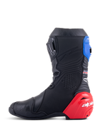 Botas Alpinestars Honda Supertech R, botas de carreras para moto, color negro con detalles en rojo brillante y azul, con un destacado deslizador de talón de TPU rojo, polaina superior azul y logotipo de Alpinestars, diseño técnico para rendimiento profesional en pista y carretera.