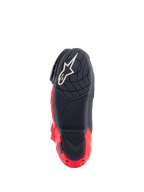 Botas Alpinestars Honda Supertech R, vista de la suela, negro y rojo brillante, con un compuesto de goma texturizada para el agarre, logotipo Astar blanco en el antepié y deslizador de la placa del talón rojo, calzado de motociclismo de competición de alto rendimiento.