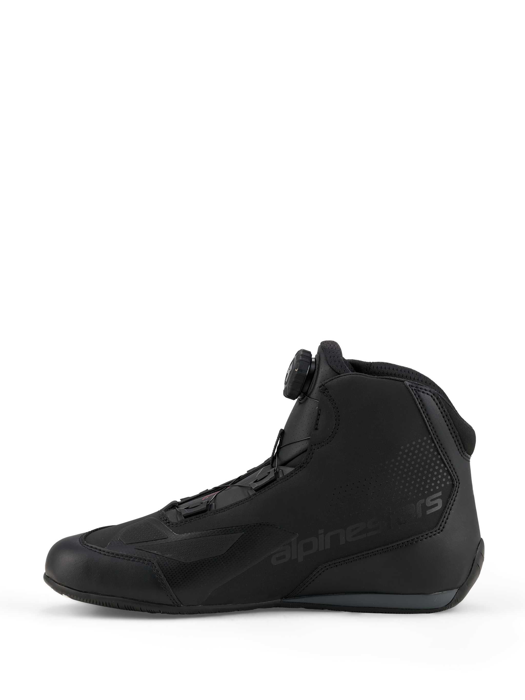 Zapatillas Alpinestars Celer, zapatillas de conducción deportiva y de competición, negro y gris oscuro, vista de perfil lateral con el dial del sistema de cierre Rotor integrado, construcción de microfibra técnica con marca Alpinestars, diseño aerodinámico para alto rendimiento
