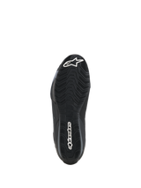 Zapatillas Alpinestars Celer, vista de la suela, compuesto de goma negra resistente al aceite con patrón de agarre ondulado texturizado, con logotipos blancos de Alpinestars en la puntera y el talón, diseñadas para tracción en las estriberas de la moto