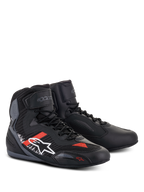 Zapatos Alpinestars Faster-3 Rideknit®, calzado para moto, en color negro, gris y rojo brillante, con parte superior de microfibra y textil de punto, logotipo Alpinestars blanco en el lateral con detalles en rojo y blanco, cierre de cordones con correa de velcro en el tobillo y diseño deportivo de carretera.
