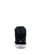Alpinestars Chrome Shoes, zapatos de moto urbanos, negro y blanco, vista trasera que muestra la construcción de ante dividido, suela de goma blanca con logotipo en el talón y pequeño detalle rectangular reflectante.