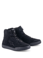 Zapatos Alpinestars Chrome, calzado de moto urbano, negro, construcción de ante dividido de caña alta, con logotipo de estrella tonal en el lateral, cierre frontal con cordones y parte superior elástica, y suela de goma plana para un estilo casual urbano.