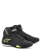 Zapatos Alpinestars Sektor, calzado para motociclismo, negro y amarillo fluorescente, diseño de corte medio con sistema de cordones rápidos y correas de velcro en el tobillo, logo Alpinestars amarillo en el lateral, construcción de microfibra ligera con acabado elegante