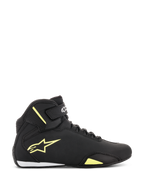 Zapatos Alpinestars Sektor, calzado para motociclismo, negro y amarillo fluorescente, vista lateral que muestra el logotipo de la estrella amarilla, correa en el tobillo con la marca y detalle blanco en el talón sobre una parte superior de microfibra elegante