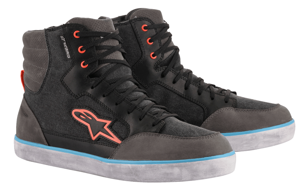 Alpinestars J-6 Waterproof Canvas Riding Shoes, negro y gris antracita, diseño de zapatilla de caña alta con logotipo y ojales naranjas, franja azul claro en la suela blanca, calzado urbano impermeable para motocicleta