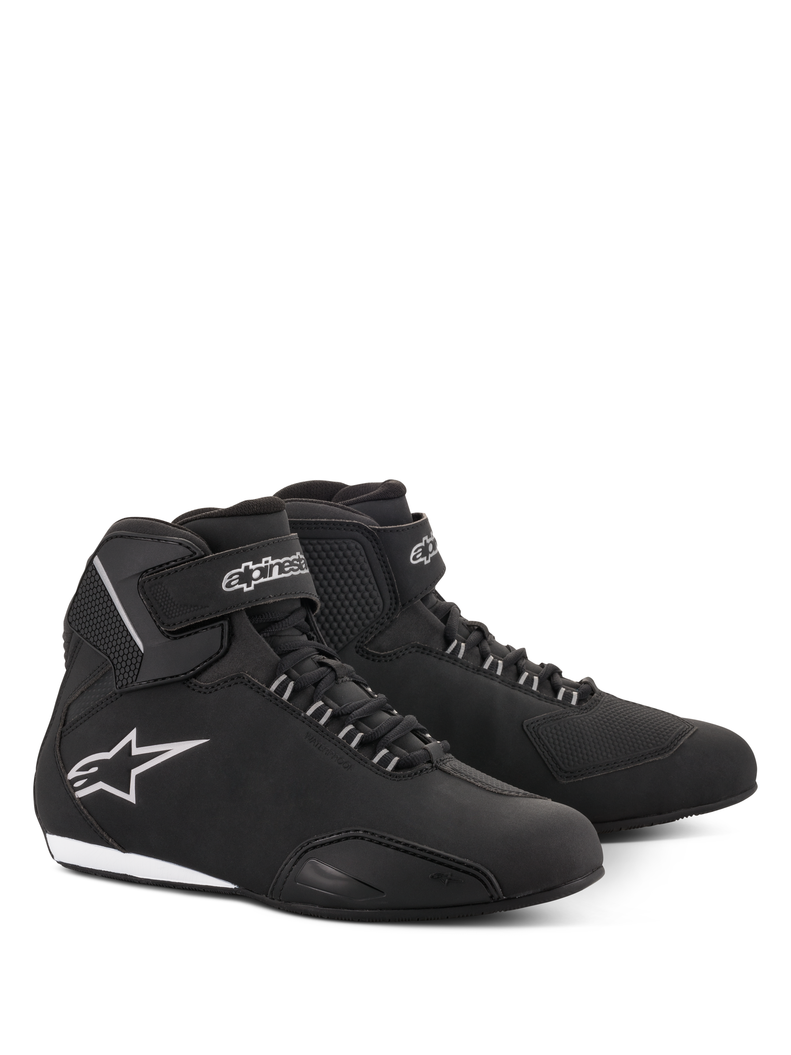 Zapatos Alpinestars Stella Sektor Waterproof para mujer, calzado de moto en color negro y plateado, parte superior de microfibra con cierre de cordones y correa de velcro en el tobillo, logo de estrella Alpinestars plateado en el lateral y suela de goma fina.