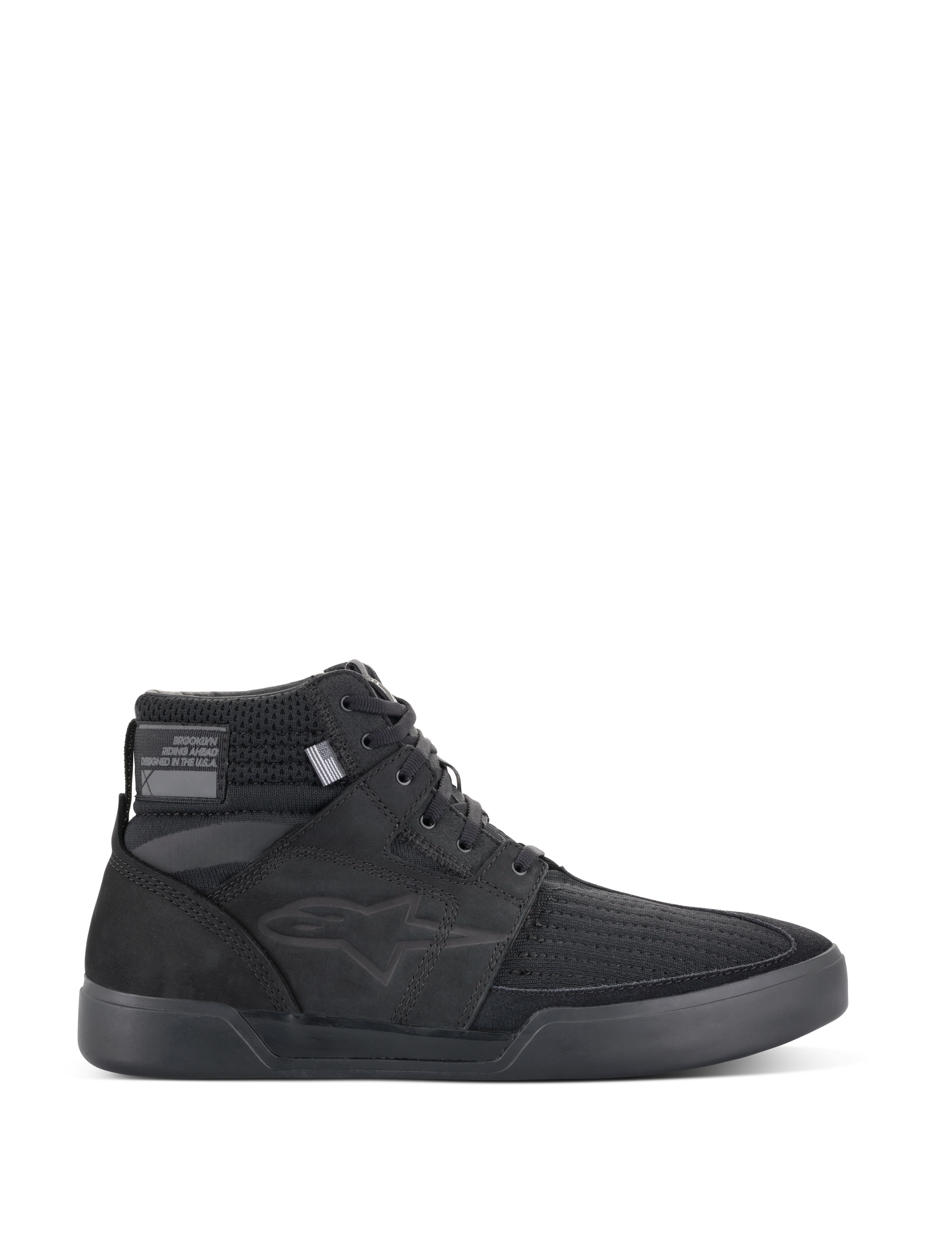 Alpinestars Primer Riding Shoes, zapatillas de moto negras, calzado urbano de caña alta, vista de perfil, parte superior de malla texturizada, suela de goma gruesa, diseño deportivo moderno con un sutil logo de estrella