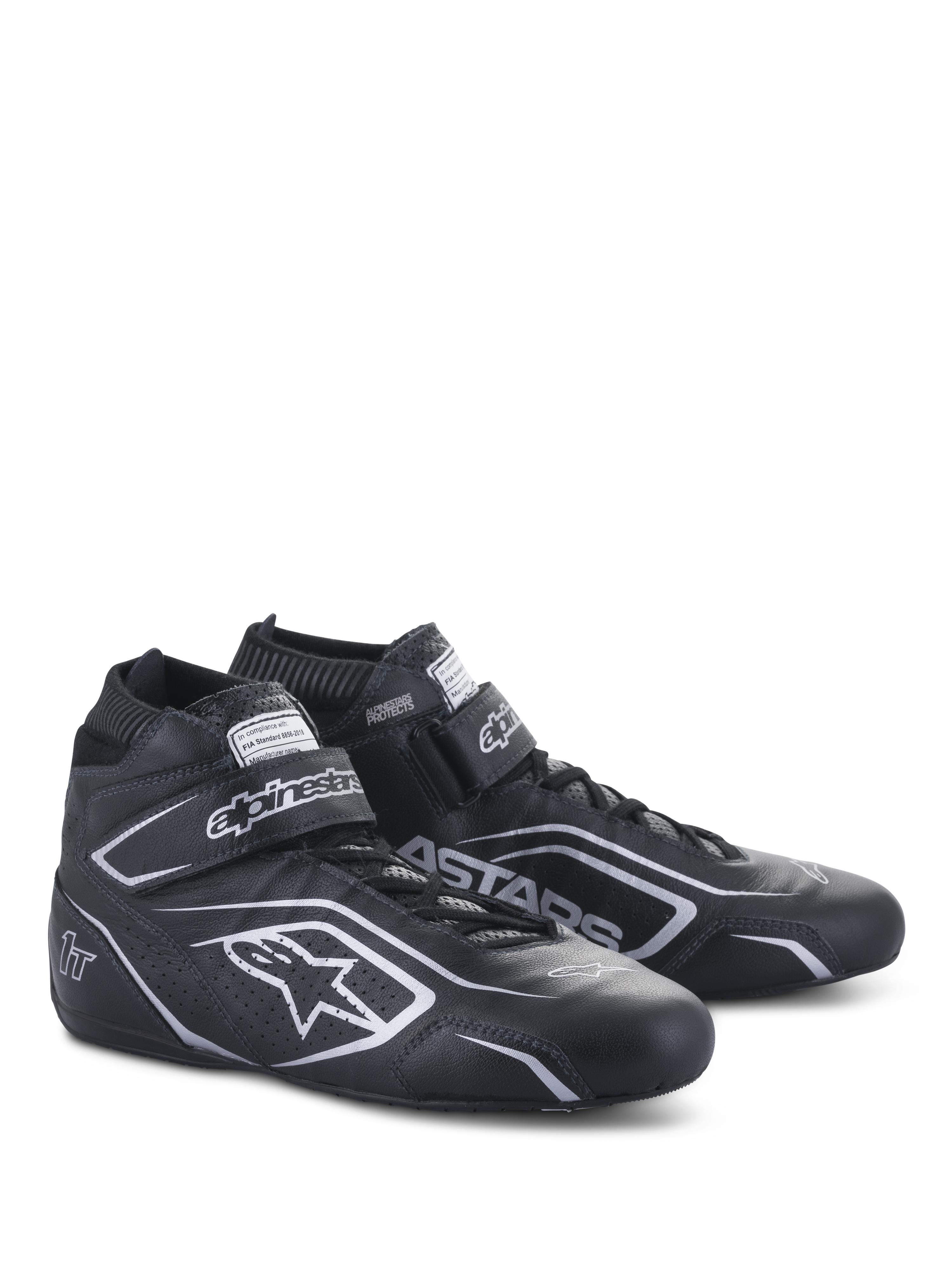 Alpinestars Tech-1 T V3 Shoes FIA, zapatos de automovilismo, negro y plata, confección en cuero de vaca con logotipos y marca Alpinestars en plata, vista lateral en ángulo con correa de gancho y bucle y cierre de cordones