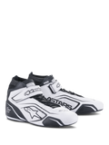 Alpinestars Tech-1 T V3 Shoes FIA, botas de carreras blancas y negras, calzado profesional de automovilismo con certificación FIA, diseño de cuero de caña alta con ventilación perforada, correa de velcro en el tobillo y marca Astars en negro.