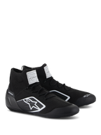 Alpinestars Supertech Shoes, zapatos de automovilismo, negros, con parte superior de punto retardante al fuego y copa del talón de fibra de carbono, logo blanco de Alpinestars en el lateral, etiquetas de certificación FIA/SFI en la lengüeta, calzado profesional para deportes de motor con un diseño estilizado
