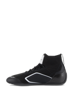 Zapatos Alpinestars Supertech, calzado para automovilismo, negro, vista de perfil lateral con parte superior tejida, talonera de fibra de carbono y acentos geométricos blancos, calzado profesional para deportes de motor