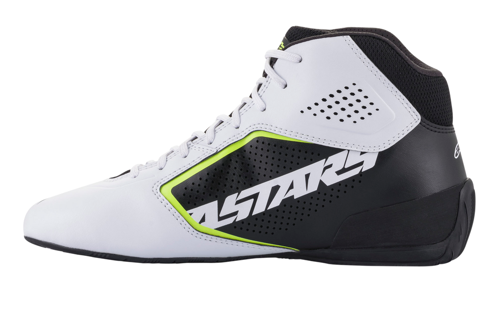 Zapatillas Alpinestars Tech-1 K Start V2, zapatillas de karting, blanco, negro y amarillo flúor, vista lateral con una parte superior de microfibra blanca perforada, panel lateral negro con el logotipo ASTARS destacado, detalles en amarillo neón y suela negra estilizada.