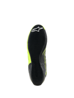 Zapatillas Alpinestars Tech-1 KX V3, calzado de karting, negro y amarillo flúor, vista inferior de la suela de goma fina con patrón de agarre texturizado y logotipo de estrella blanca en el talón, diseñadas para el rendimiento en deportes de motor