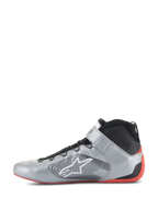 Alpinestars Tech-1 Z V3 Shoes FIA, zapatos de automovilismo, plata oscuro, negro y rojo, perfil lateral de un calzado de conducción profesional, parte superior de cuero plata metalizado con cuello de punto negro, con el logotipo blanco de Alpinestars y una suela de goma roja fina