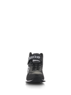 Zapatos Alpinestars Radar, calzado de automovilismo para equipos de boxes, negro y blanco, vista frontal que muestra cordones negros y una correa de tobillo de gancho y bucle con marca en blanco, parte superior de cuero perforado con puntera reforzada, calzado profesional para equipos de boxes