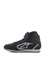 Zapatos Alpinestars Radar, calzado para equipos de boxes de automovilismo, negro y blanco, perfil de caña alta con parte superior de cuero perforado, icónico logo A-star blanco en el lateral y correa de tobillo ajustable de gancho y bucle.