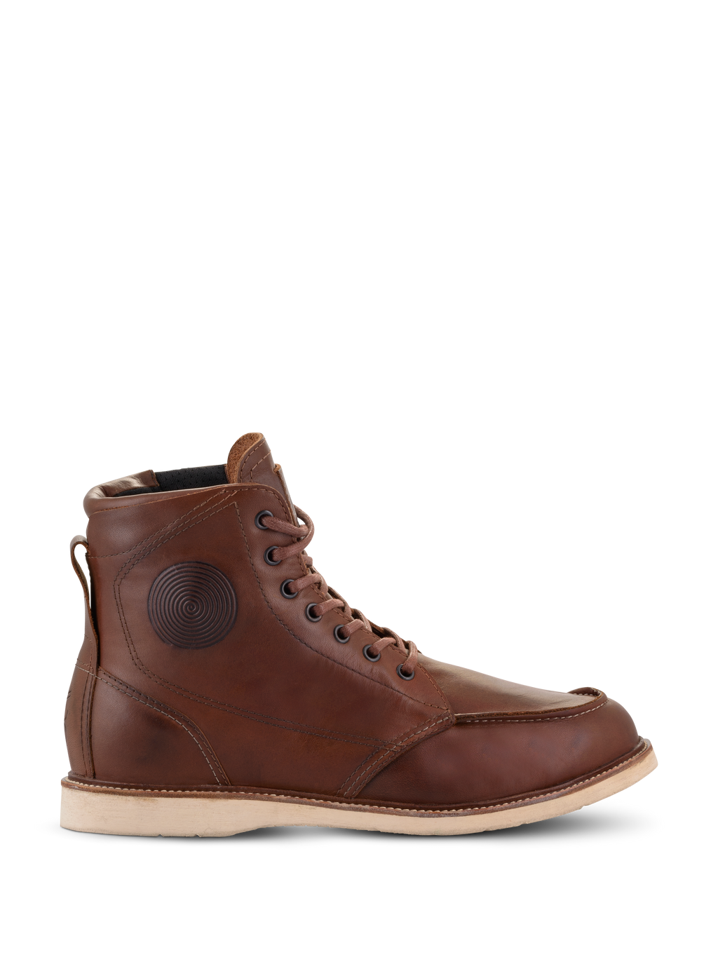 Zapatos Alpinestars Oscar Monty V2, botas de moto de cuero marrón, suela de cuña blanca, puntera moc toe, detalle circular grabado en el tobillo, calzado urbano heritage para montar