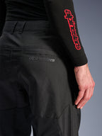 Alpinestars C-1 Air Pants, pantalones de moto textiles negros, primer plano del bolsillo trasero con un sutil logotipo gris de Alpinestars, con paneles de malla transpirable y polifabric duradero, diseñados para la comodidad en la conducción urbana