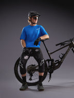 Jersey Alpinestars A-Dura Air SS azul y shorts Black Camo en ciclista con bicicleta de montaña en un estudio.