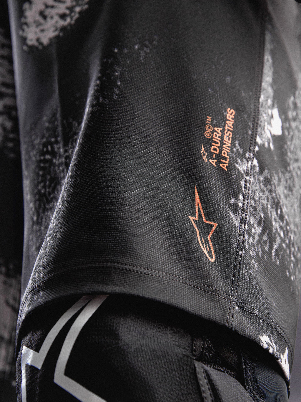 Pantalones cortos A-Dura Ride en camuflaje negro con logotipo naranja Alpinestars y tejido elástico duradero para MTB.