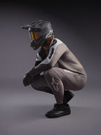 Maillot y pantalones MTB A-Supra Elite gris degradado, con casco integral negro y gafas para competición.