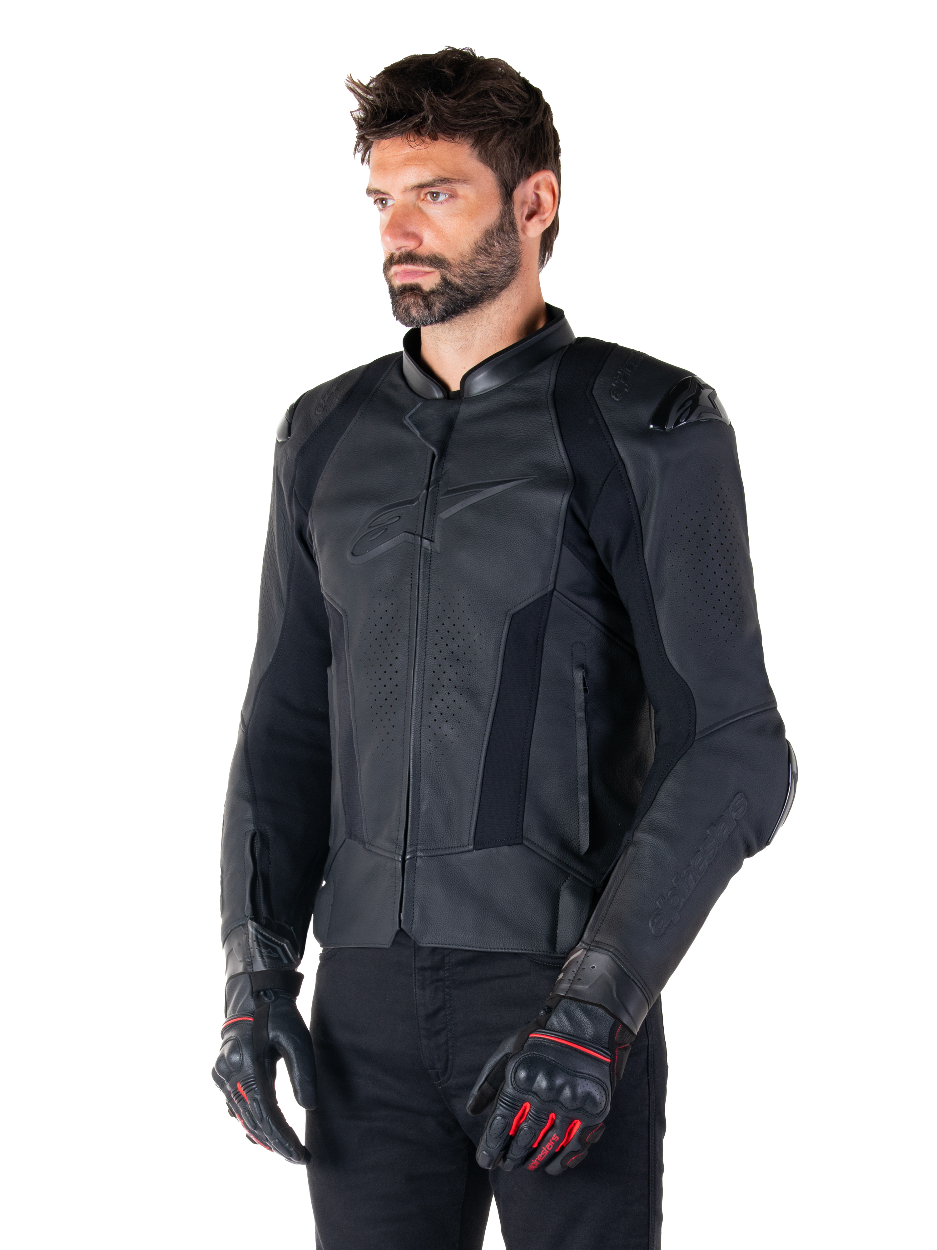 Piloto usando la chaqueta de cuero Alpinestars Missile V3 en negro, de cuero bovino premium con paneles perforados en el pecho y protectores externos DFS en los hombros, combinada con pantalones negros y guantes de carreras en negro y rojo.